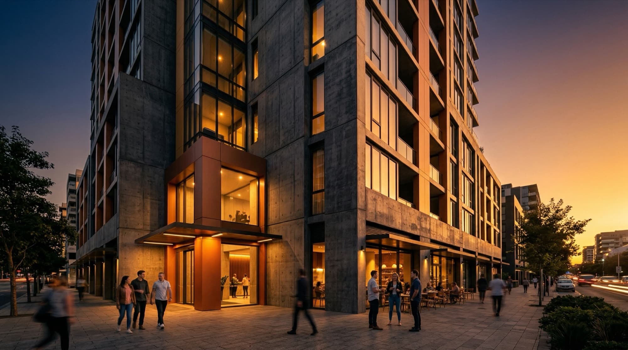 A mixed-use residential building at dusk, warm interior lights on, people at street level.